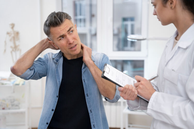 Doctor performing routine medical checkup for a man with autoimmune symptoms