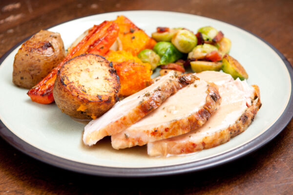 holiday feast turkey dinner with cranberry sauce, roasted vegetables and brussels sprouts